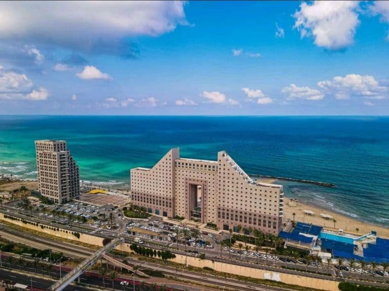 מבט אווירי על בניין אלמוג ומגדלי חוף הכרמל על קו החוף בחיפה